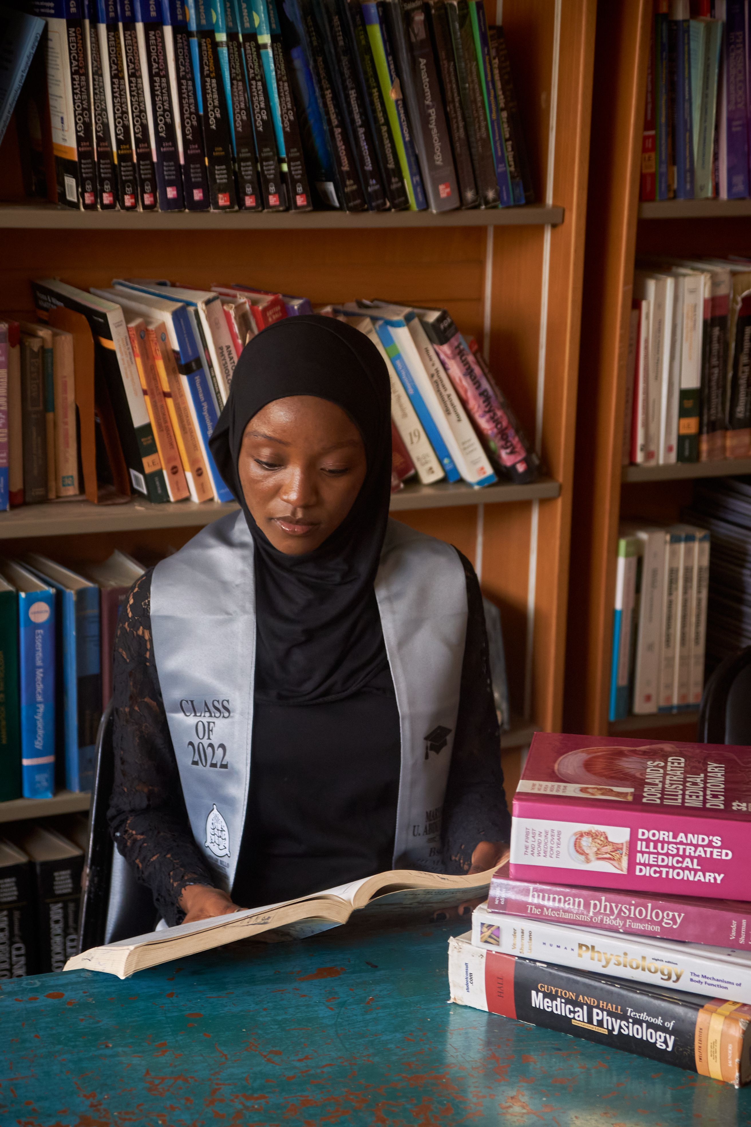 A university graduate reading books in a library